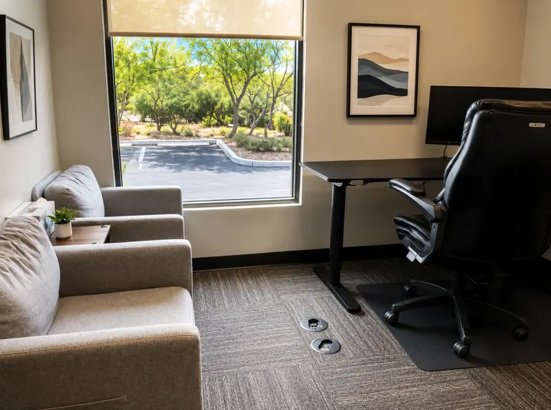 Private office Suite 104 at Spoke Coworking with an ergonomic sit-stand desk, monitor, and guest seating.