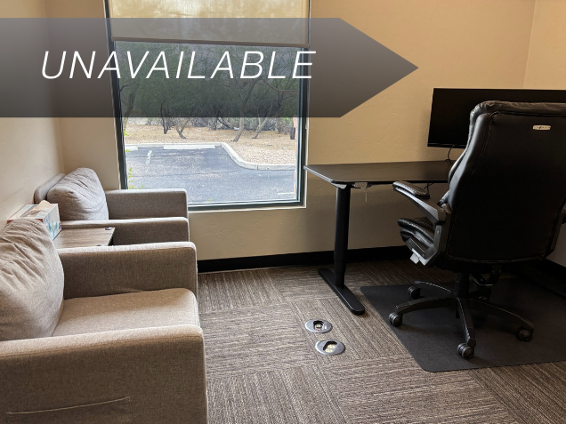 Private executive office Suite 104 at Spoke Coworking with a sit-stand desk, curved monitor, and guest armchairs.