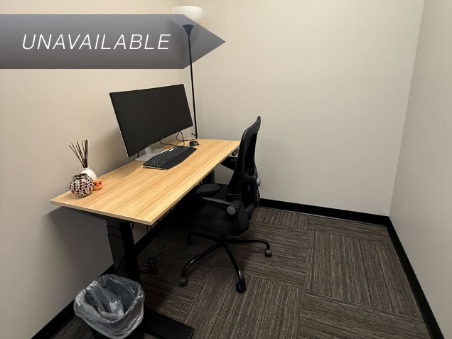 Private micro suite 127 with a bamboo sit-stand desk, curved monitor, and ergonomic chair for focused work.