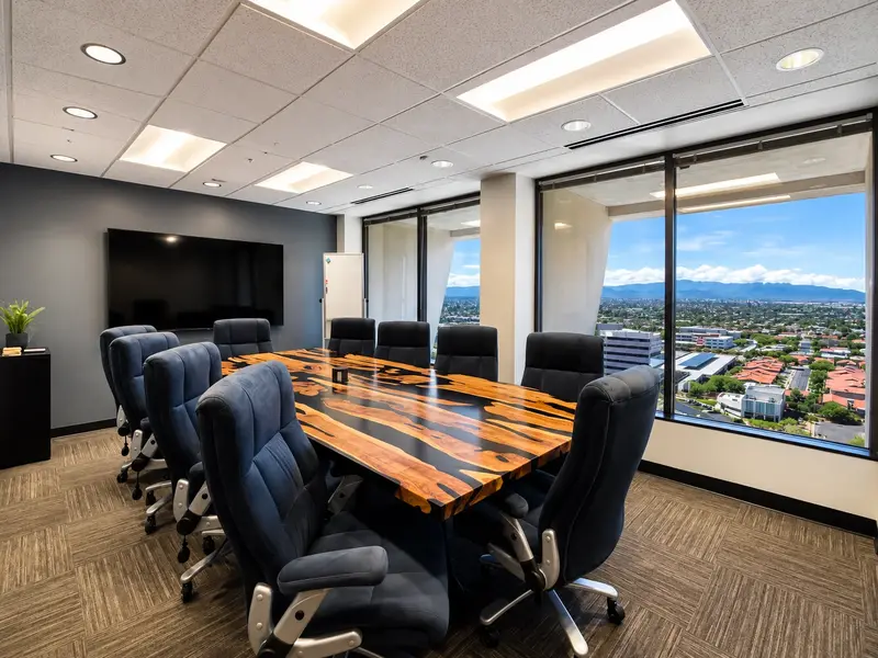 Executive boardroom at Spoke Coworking featuring a custom river table, ergonomic seating, and panoramic mountain views.