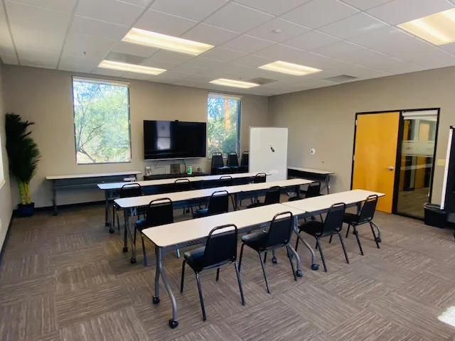 The Flex Space training and meeting room with classroom seating for 25, a 75-inch 4K TV, and a whiteboard.