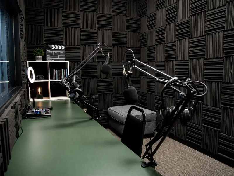 Soundproof podcast studio at Spoke Coworking with microphones, headphones, audio mixer, and ring light.