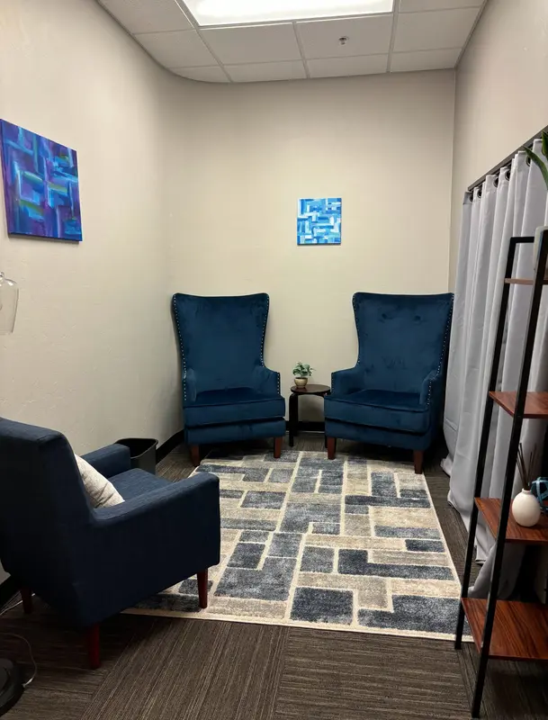 The Huddle Hub private meeting room with navy blue velvet chairs and a geometric rug for intimate one-on-one sessions.