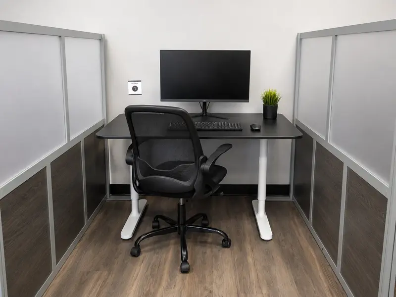 Semi-private Hot Desk 1 workspace setup at Spoke Coworking in Tucson with monitor and ergonomic chair.