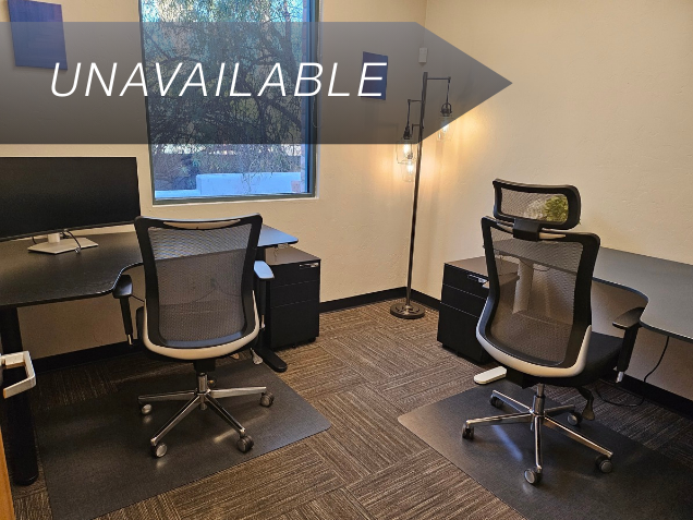 Private executive office Suite 125 with dual workstations, ergonomic chairs, and a window for natural light.