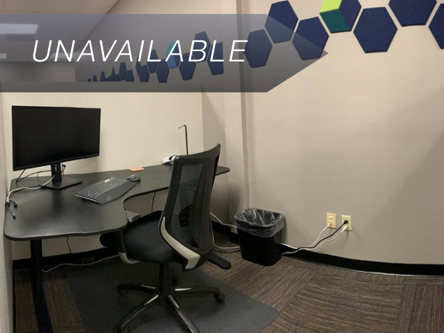 Semi-private dedicated desk 202 with a sit-stand desk, curved monitor, and ergonomic chair at Spoke Coworking.