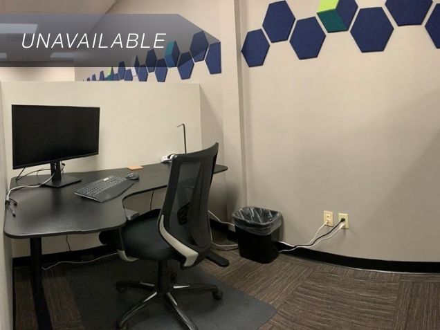 Semi-private dedicated Desk 202 at Spoke Coworking with a sit-stand desk, curved monitor, and ergonomic chair.