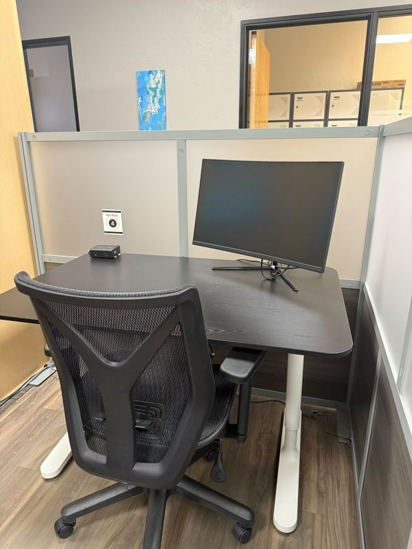 Semi-private Hot Desk 4 in Tucson featuring a curved monitor and ergonomic chair for a productive coworking experience.