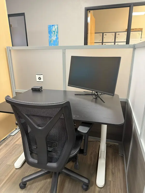 Semi-private Hot Desk 4 in Tucson featuring a curved monitor and ergonomic chair for a productive coworking experience.