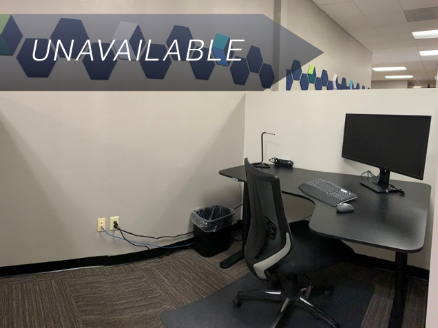 Semi-private dedicated desk 203 with a curved monitor and sit-stand desk in a modern coworking office.