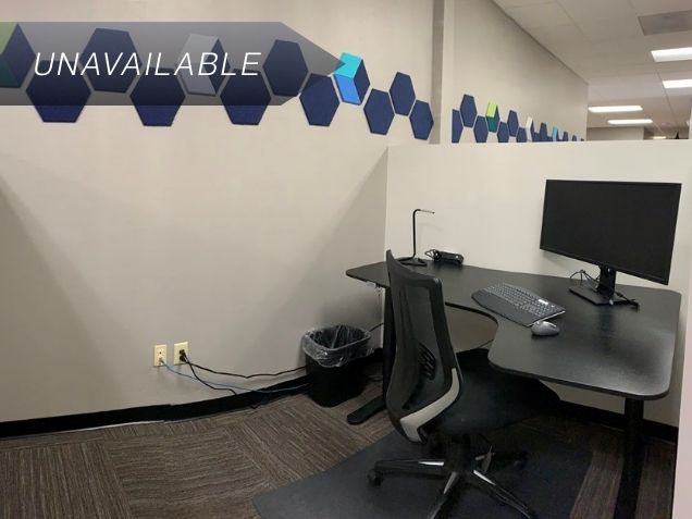 Semi-private dedicated desk 203 with an electric sit-stand desk and curved monitor in a modern coworking space.