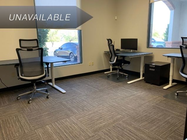 Modern private team office Suite 127 at Spoke Coworking featuring electric sit-stand desks and ergonomic chairs.