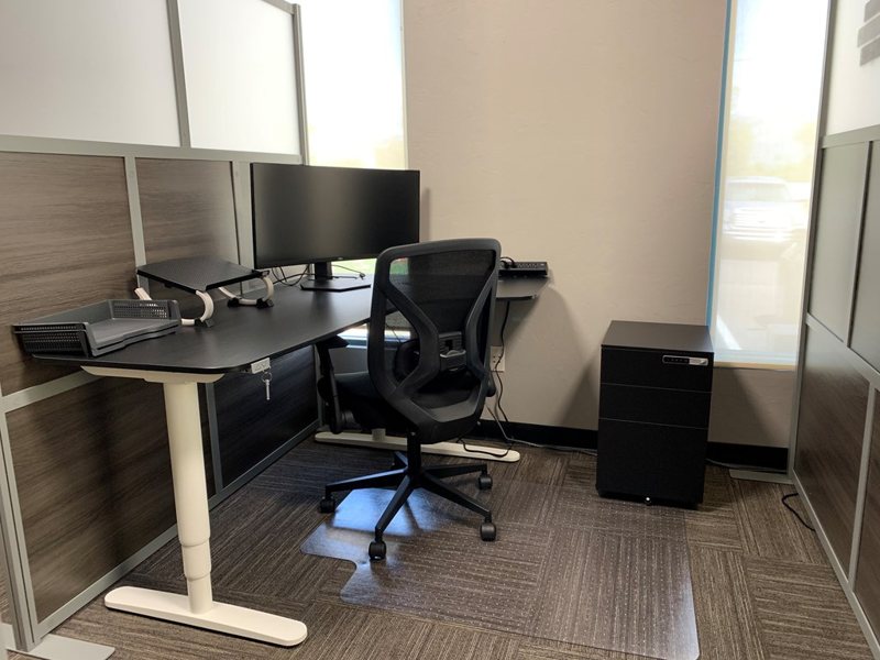 Semi-private dedicated desk 206 with a 34-inch curved monitor, electric sit-stand desk, and ergonomic chair.