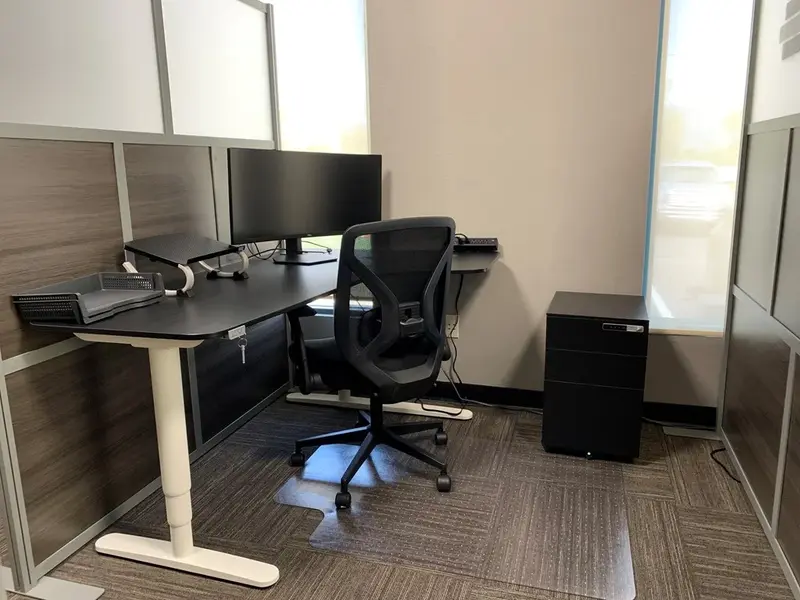 Semi-private dedicated workspace at Desk 206 featuring an electric sit-stand desk, curved monitor, and ergonomic chair.