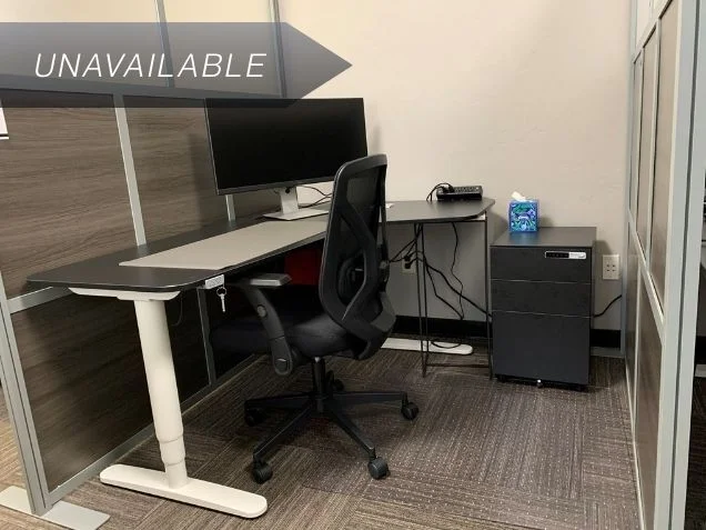 Semi-private Dedicated Desk 209 at Spoke Coworking featuring an electric sit-stand desk, curved monitor, and mesh chair.