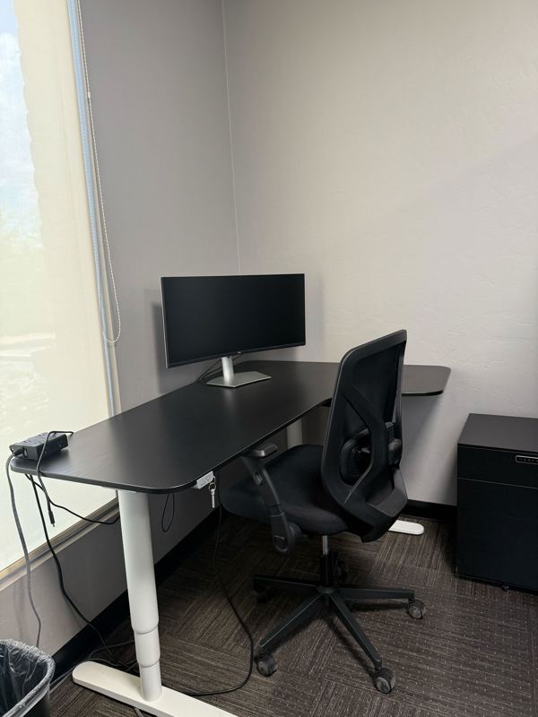 Semi-private dedicated desk 210 at Spoke Coworking with a sit-stand desk, curved monitor, and ergonomic chair.