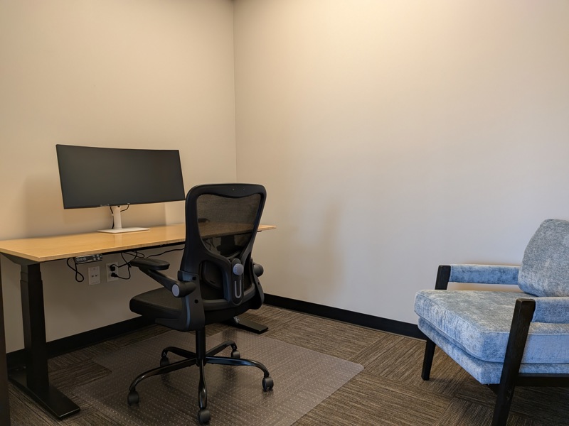 Private Mini Suite 110 office with a sit-stand desk, 34-inch curved monitor, and ergonomic chair for focused work.