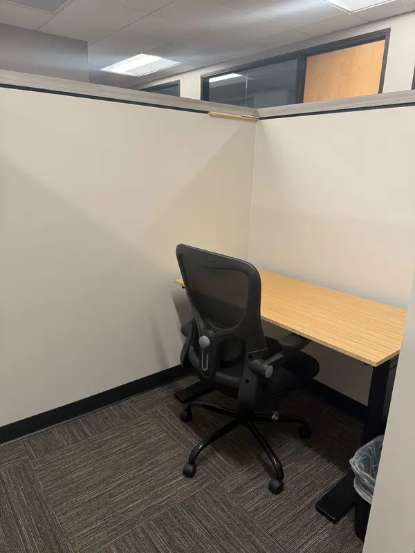 Semi-private dedicated Desk 215 featuring a bamboo sit-stand desk and ergonomic mesh chair with high privacy walls.