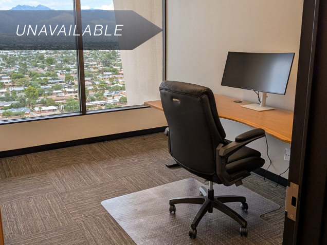 Private executive office Suite 122 featuring a bamboo sit-stand desk, curved monitor, and scenic mountain views.