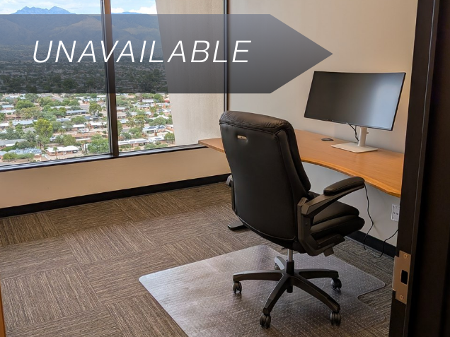 Private executive office Suite 122 with a bamboo sit-stand desk, curved monitor, and scenic mountain views.