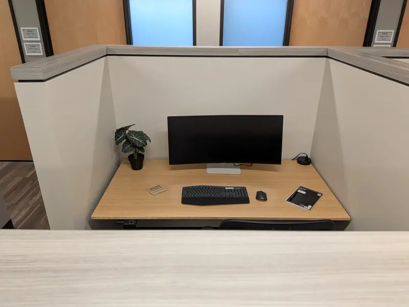 Semi-private dedicated desk 204 featuring an electric bamboo sit-stand desk and a 36-inch curved monitor.