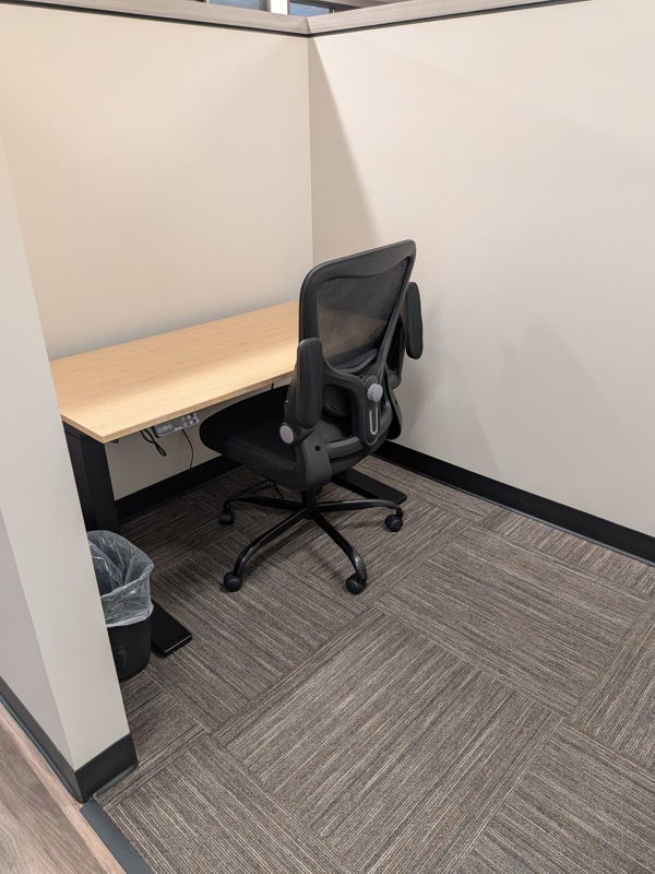 Semi-private dedicated desk 205 with an electric bamboo sit-stand desk and ergonomic mesh chair for a productive workspace.