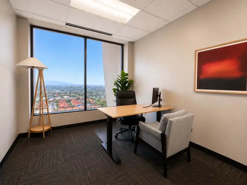 Private Suite 142 at Spoke Tower Suites with a sit-stand desk, curved monitor, and panoramic window view.