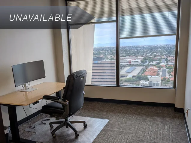Private executive office Suite 143 with a bamboo sit-stand desk, curved monitor, and scenic mountain views from the window.