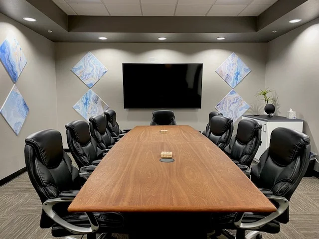 Modern board room in East Tucson with a large wooden conference table, executive chairs, and an 82-inch 4K TV.