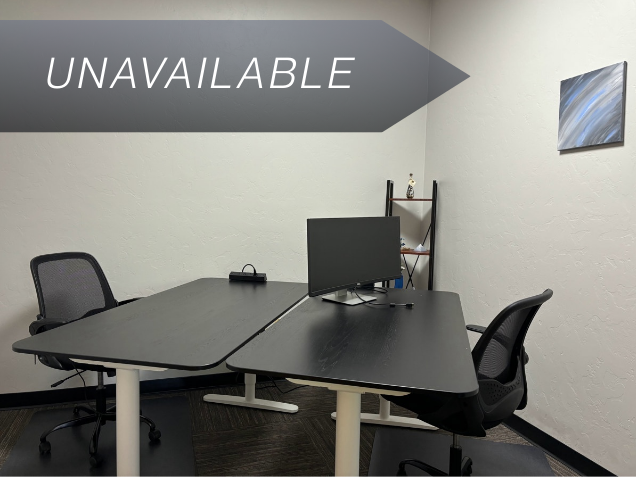 Private Junior Suite 103 at Spoke Coworking with sit-stand desks, a curved monitor, and ergonomic chairs for focused work.