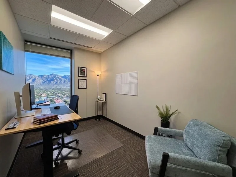 Private office suite at Spoke Coworking Tower Suites in Central Tucson, featuring a sit-stand desk and scenic mountain views.