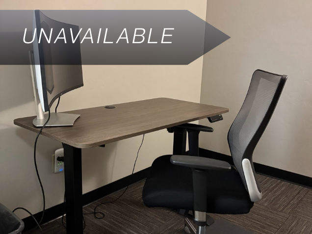 Private office Suite 107 in East Tucson featuring a sit-stand desk, curved monitor, and ergonomic mesh chair.