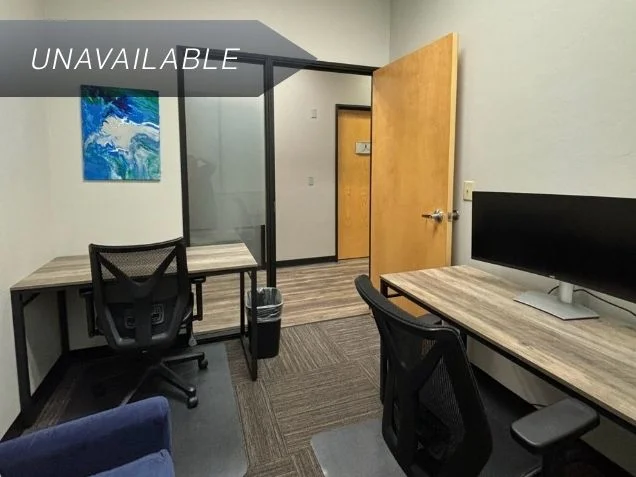 Private office Suite 123 featuring two desks, ergonomic chairs, and a curved monitor for a productive workspace.