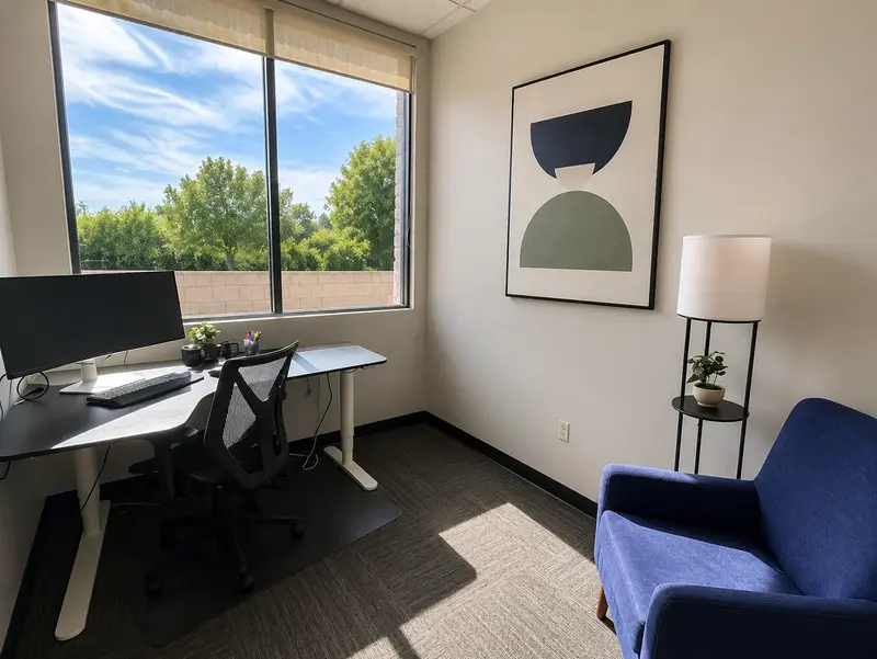 Spoke Coworking Suite 121 private office featuring a sit-stand desk with curved monitor and large window.