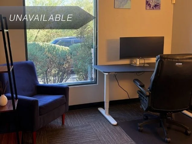 Private executive office Suite 106 at Spoke Coworking with a sit-stand desk, curved monitor, and guest seating.